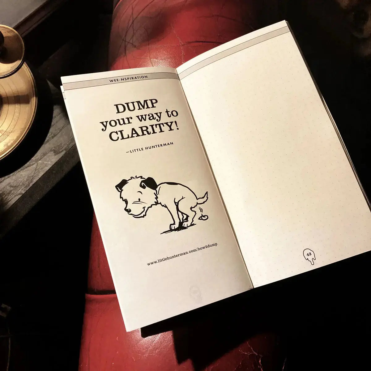 An open dotted version of a Little Hunterman's Dump-Journal showing an annotation page and one doggie dump-quote: "Dump your way to clarity!"