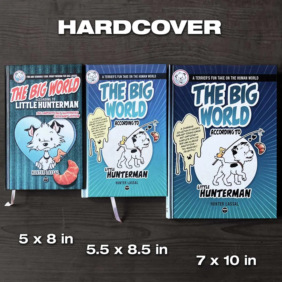 This image shows a size comparison between the deprecated and the current standard editions, as well as the premium version of the Hunterman hardcover books. The image shows all three of the hardcovers, labled, next to each other on a dark wooden surface.