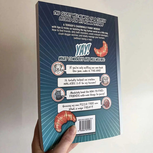 Hand holding a paperback version showing the back cover of the premium edition of The Big World According to Little Hunterman by Hunter Lassal