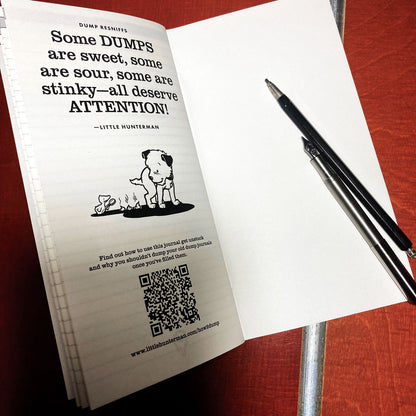 Little Hunterman's lined Dump-Journal open on a desk showing the last page with a doggie dump-quote and the QR-code to an explanatory page.