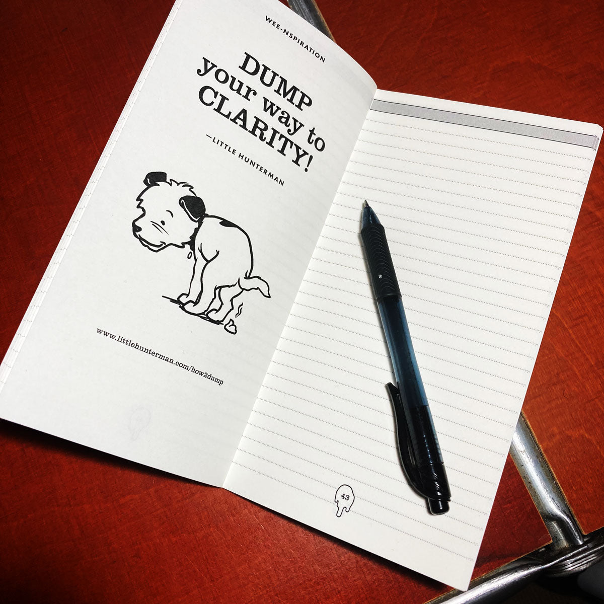 Little Hunterman's Dump-Journal open on a desk showing one content page and one doggie dump-quote.