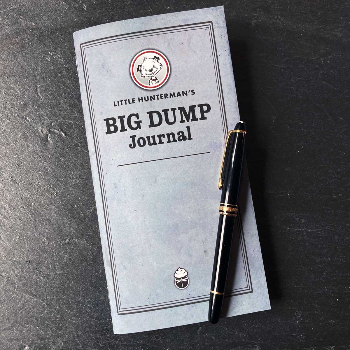 Little Hunterman's Big Dump Journal lying on a desk with a fountain pen.
