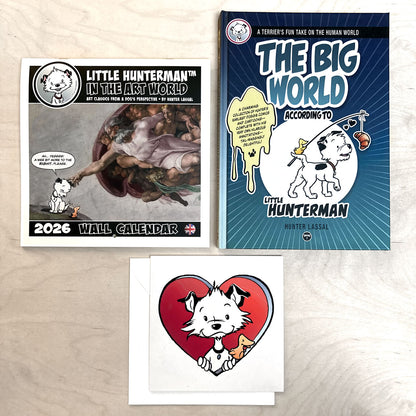 A calendar, a book, and a large card featuring a cartoon dog character on a light wooden surface