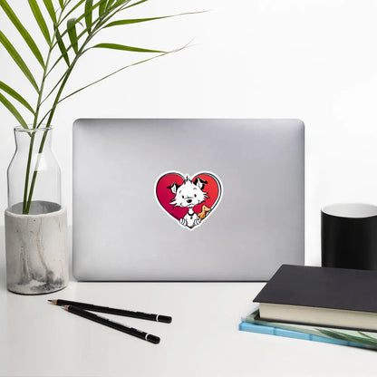 Image shows a desk-like situation with a notebook, a plant, books and pencils with one of Little Hunterman's "Sticky Doggie Love" stickers attached to the back of the open notebook lid. 