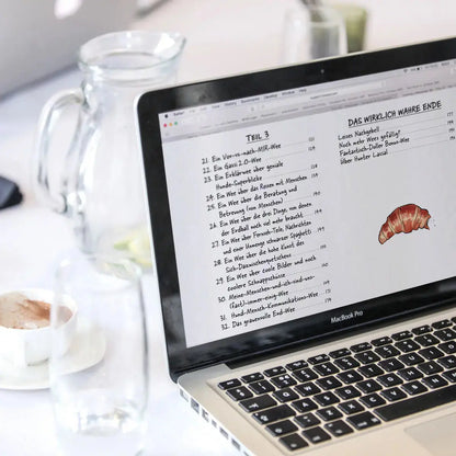 A photo of a notebook showing the content page of Hunter Lassal's eBook "Die große Welt des kleinen Huntermann" on a table.