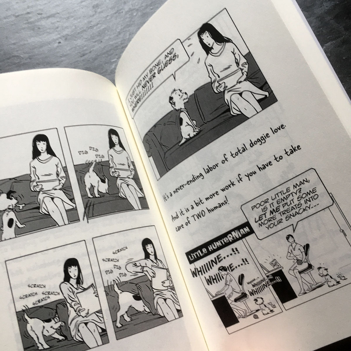 The Big World According to Little Hunterman, retailer version hardcover with black and white illustrations and creme colored paper. This images shows an open book on a table giving you a glimpse of two illustrated content pages. 
